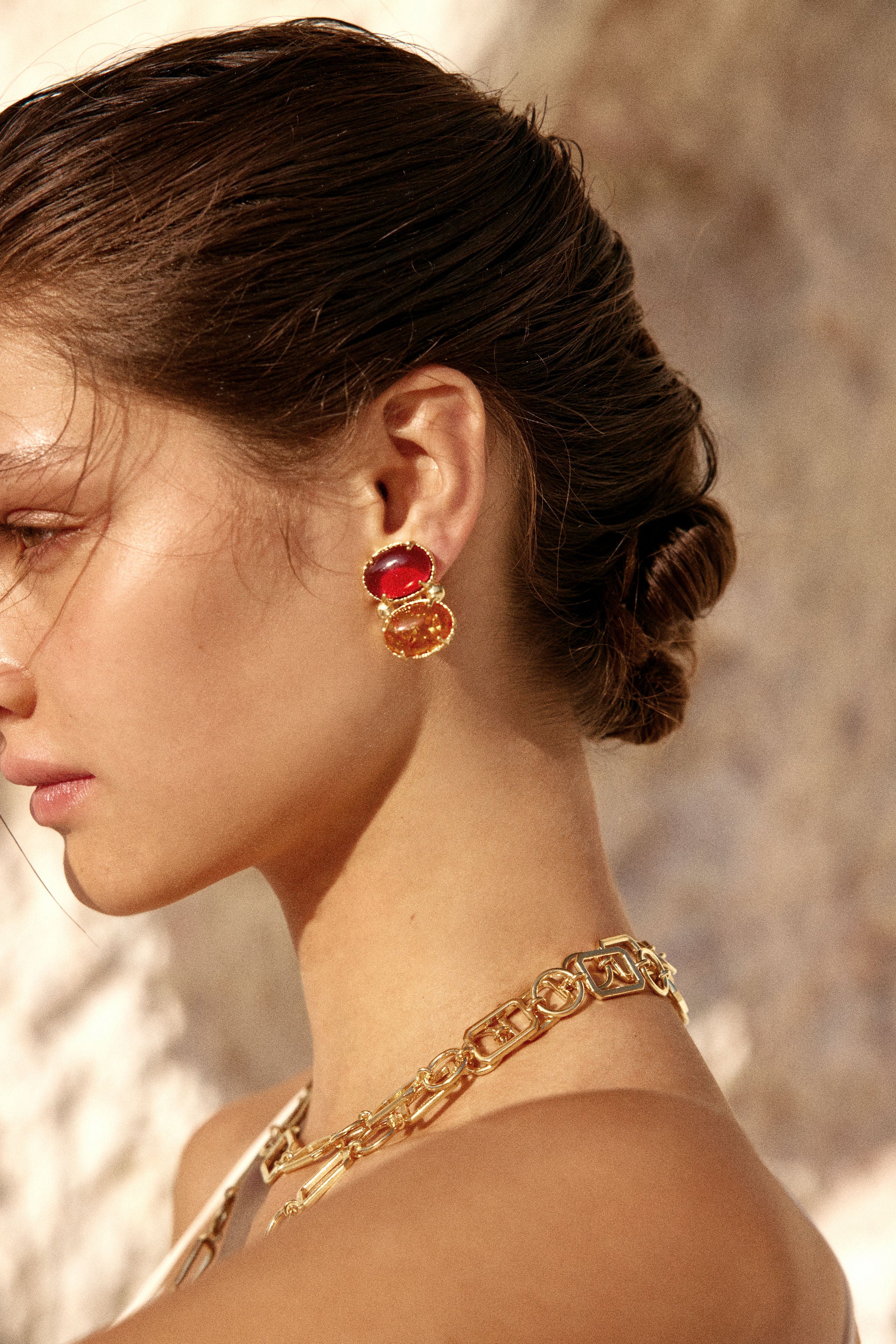 Christie Nicolaides Lolli statement stud earrings with hot pink and orange amber stones, 24k gold plated brass on model